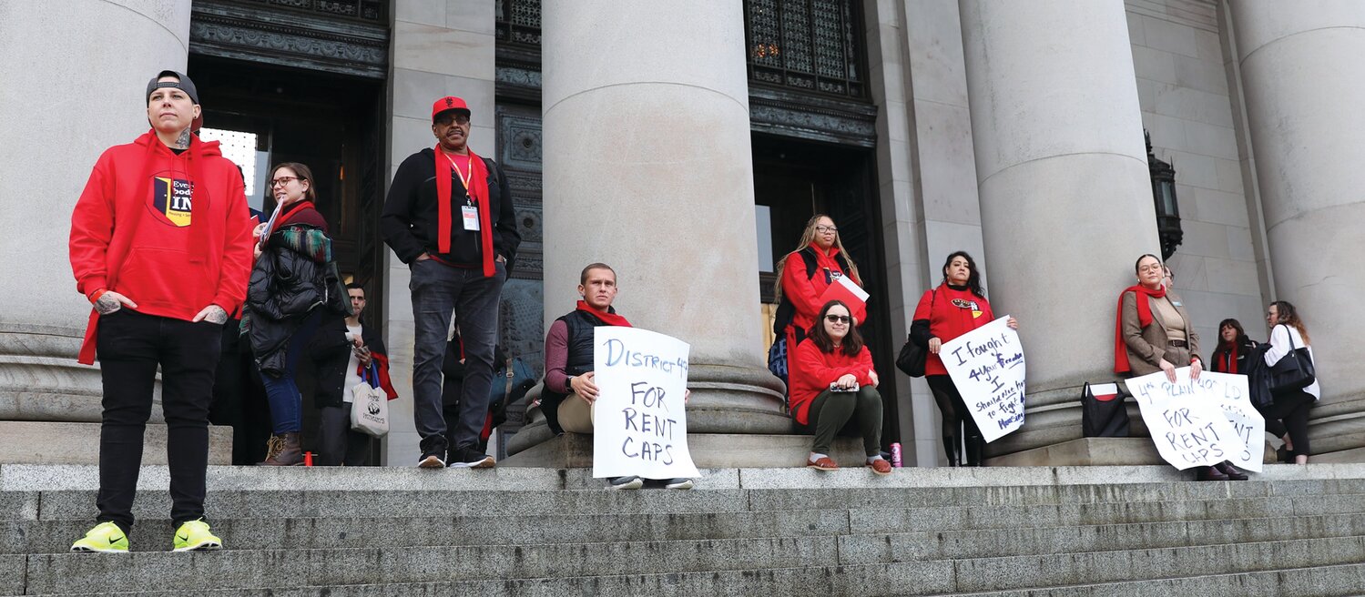 Protesters gather at the top of the Capitol’s North steps, among them Vancouver residents Jeremy Hopkins of SeaMar Community Health Services and Duana Johnson from Washington Low Income Housing Alliance.